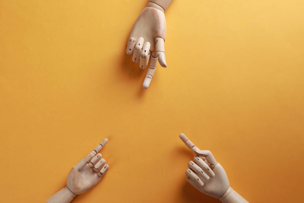 Wooden mannequin hands on orange background, flat lay - Photo, image