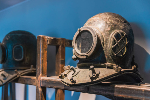 Um grupo de capacete de mergulho de metal antigo, polvilhado no quarto - Foto, Imagem
