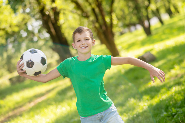 Joyful boy running with ball in park - Φωτογραφία, εικόνα