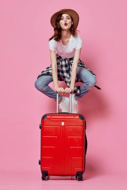 весела жінка Турист сидить на червоній валізі аеропорту польоту
 - Фото, зображення