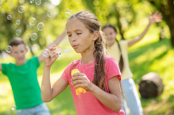 Girl blowing air and flying soap bubbles - Photo, Image