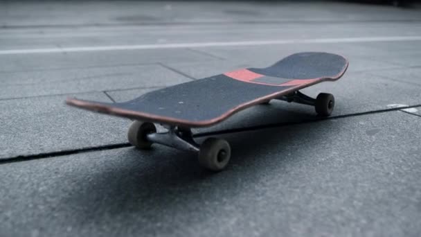 Schwarze Tafel mit weißen Rädern an der Stadtstraße. Skateboard für Tricks. - Filmmaterial, Video