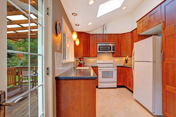 Luminosa sala de cocina con tragaluz y cubierta de salida
 - Foto, Imagen