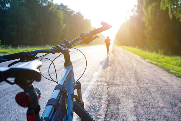 Bisiklet, ön ve arka plandan kaçan bir adamın silueti bokeh etkisi ile bulanıklaştı - Fotoğraf, Görsel