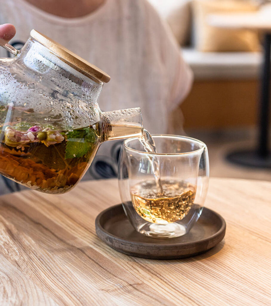 Διαδικασία τσάι παρασκευής. Ζεστό φυτικό ή πράσινο τσάι με μέντα και ροδοπέταλα. Επιλεκτική εστίαση. - Φωτογραφία, εικόνα