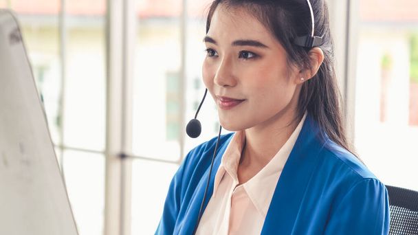 Businesswoman wearing headset working actively in office - Photo, Image