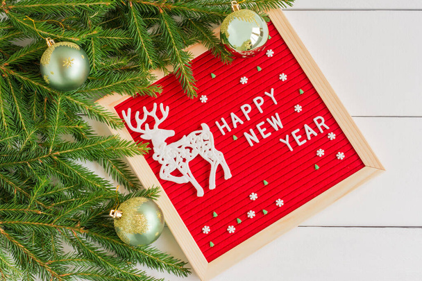 Letter board new year and christmas concept. Top horizontal view copyspace christmas decorations and fir tree on white wooden background. - Photo, image