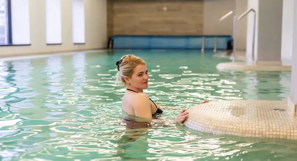 Beautiful woman in resort spa swimming pool - Fotoğraf, Görsel