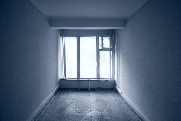 Порожня покинута кімната з великим вікном у місті в холодних кольорах
. - Фото, зображення