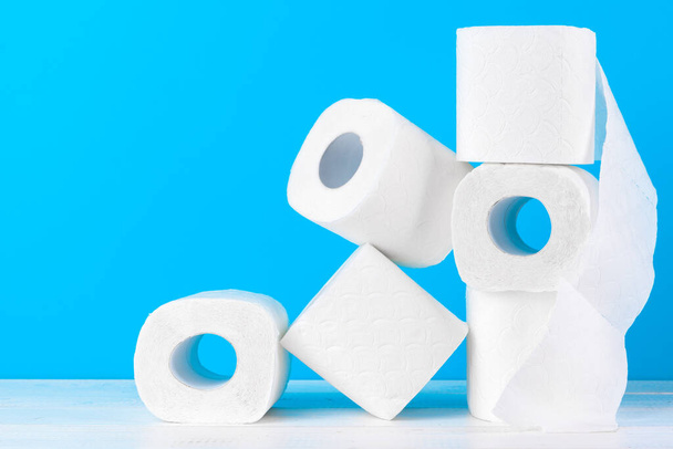 Toilet paper rolls stacked against blue background - Valokuva, kuva