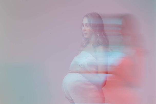 Donna incinta in bianco abito lungo in fantasia foto di stile. - Foto, immagini