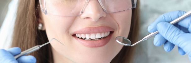 Portret uśmiechniętej kobiety z pięknymi białymi zębami na wizycie u dentysty - Zdjęcie, obraz