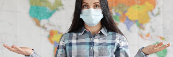Ritratto di donna in maschera protettiva medica sullo sfondo della mappa del mondo - Foto, immagini