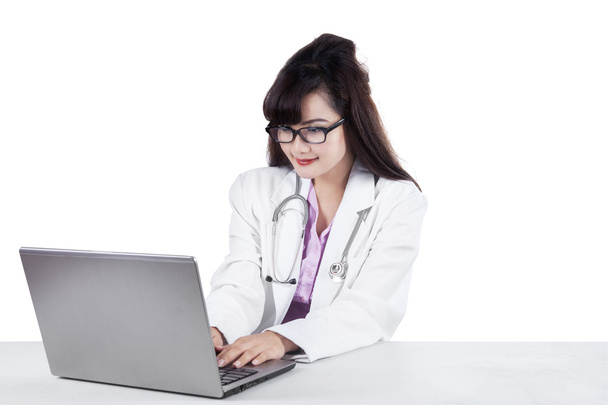 Female physician typing on laptop - Foto, Imagen