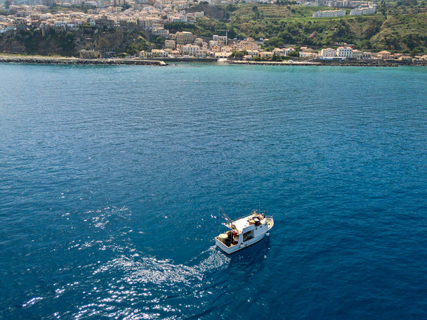 Letecký pohled na rybářské plavidlo v modrém moři u pobřeží Kalábrie, Itálie - Fotografie, Obrázek