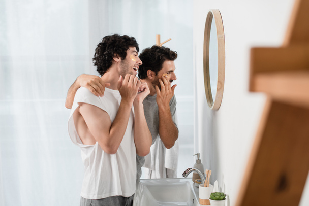 счастливая пара геев, применяющих повязки на глаза в ванной комнате - Фото, изображение