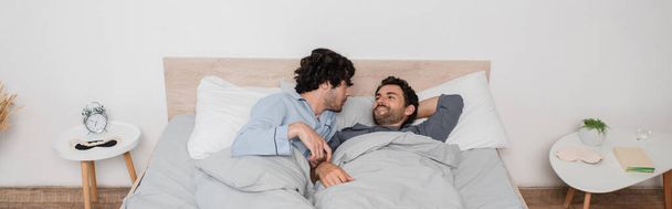 gay couple lying on bed in morning, banner - 写真・画像