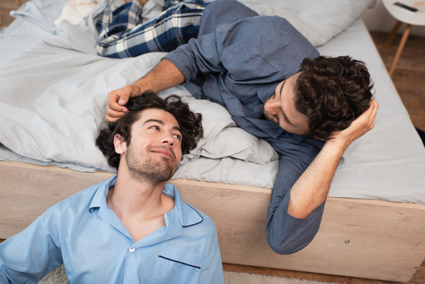 caring man stroking hair of boyfriend in bedroom - Fotó, kép