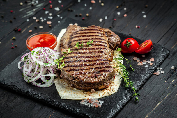 Beef steak. Grilled meat. Dry Aged Barbecue Ribeye Steak on wooden background. banner, menu, recipe place for text, top view. - Foto, imagen