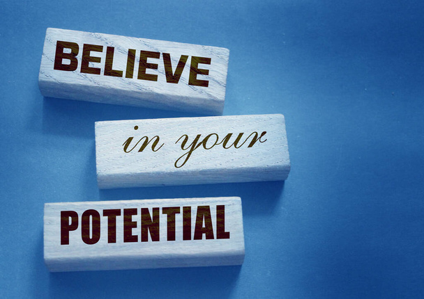 Верьте в Ваше потенциальное слово, написанное на деревянных блоках. Мотивация к достижениям в бизнесе или карьере. - Фото, изображение