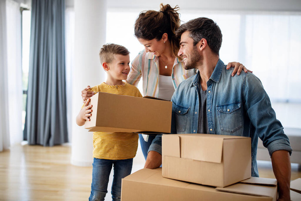 Family unpacking cardboard boxes at new home. New house, family, insurance concept. - 写真・画像
