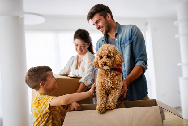 Happy family unpacking boxes in new home on moving day. People, real estate, new home concept - Φωτογραφία, εικόνα