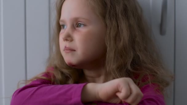 Opfer von Missbrauch von Kindern und häuslicher Gewalt. Nahaufnahme eines verängstigten kleinen Mädchens mit ramponiertem Gesicht, das allein sitzt und weint - Filmmaterial, Video