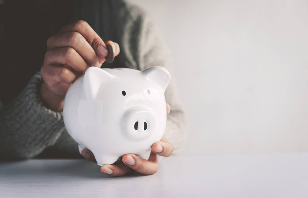 Woman hand and white piggy bank to saving money concept .budget, financial. - Фото, зображення