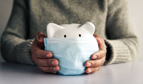 Woman hand and white piggy bank to saving money concept .budget, financial. - Фото, зображення