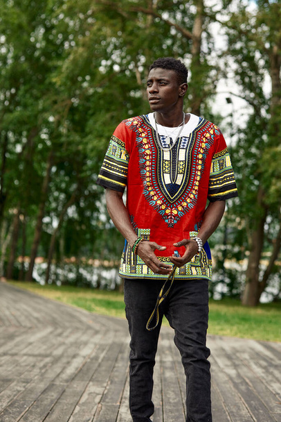 Африканський чоловік з південноафриканського національного одягу, чорний юнак, який відпочиває в парку в національному одязі.. - Фото, зображення