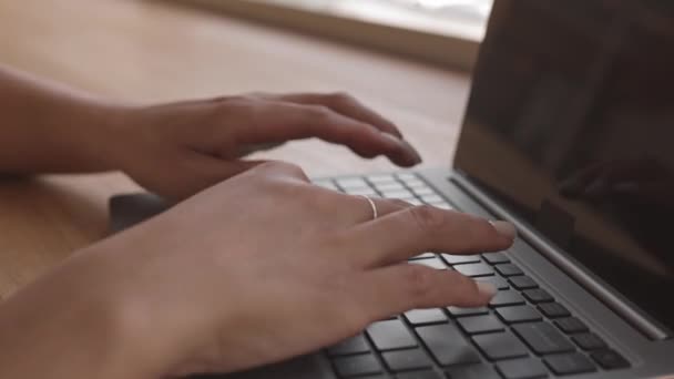 Zbliżenie żeńskich dłoni na klawiaturze komputera przenośnego - Materiał filmowy, wideo