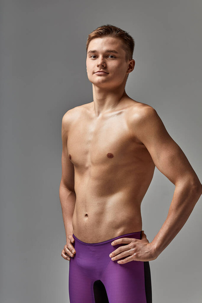 Young swimmer in excellent physical shape, on a gray background with copy space, call for sports, advertising banner - Foto, imagen