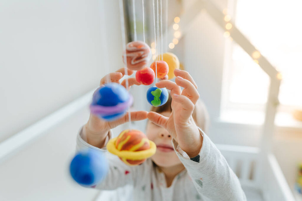 Kislány játszik játék bolygók egyedül készült színes penész agyag beltéri - Fotó, kép