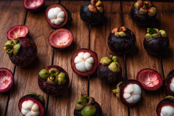 Мангостатеві фрукти на дерев'яному фоні, літні фрукти
 - Фото, зображення