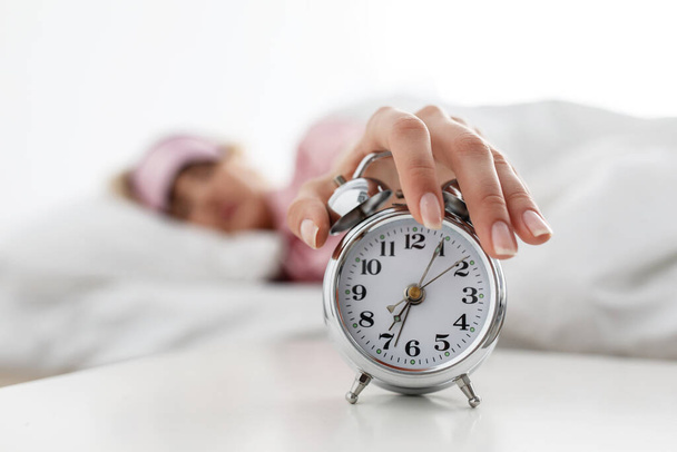 Kobieta leżąca w łóżku i próbująca się obudzić, wstaje wcześnie do pracy - Zdjęcie, obraz