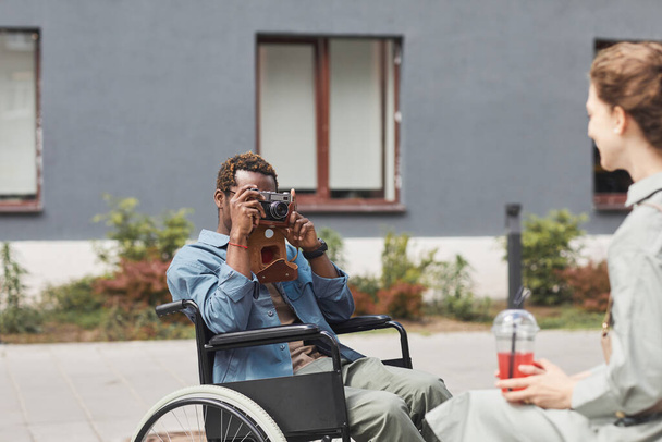 Photographe en fauteuil roulant prenant une photo de femme - Photo, image