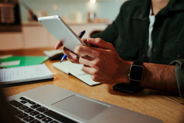 Mieszany przedsiębiorca wyścigowy pracujący na tablecie cyfrowym, siedząc w biurze domowym i realizując oferty biznesowe  - Zdjęcie, obraz