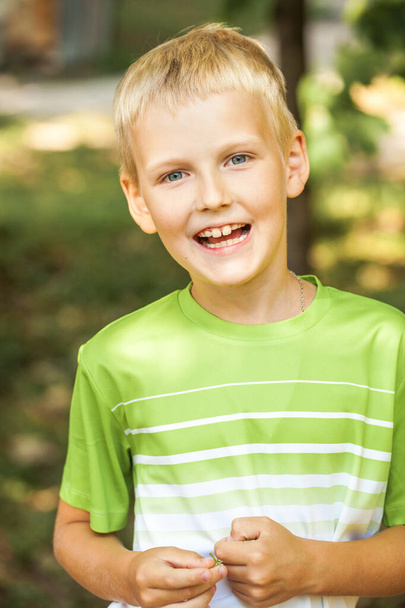 Close-up portrait of a little boy in a summer park - Фото, изображение