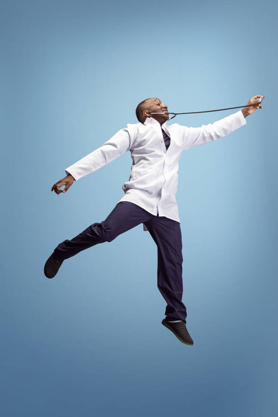 One funny doctor, therapeutic or medical advisor posing isolated on blue studio back ground. Funny meme emotions. Concept of healthcare, care, medicine and humor. - Fotó, kép