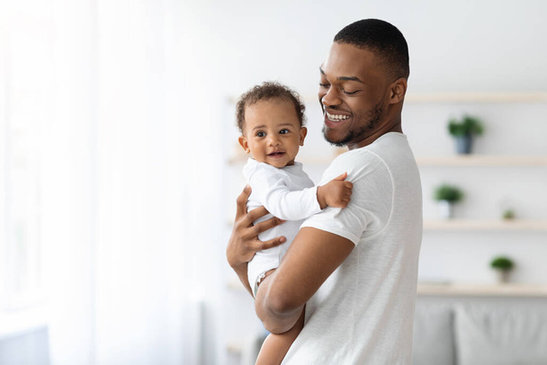 Felicità della paternità. Giovane papà nero con bambino piccolo sulle mani - Foto, immagini
