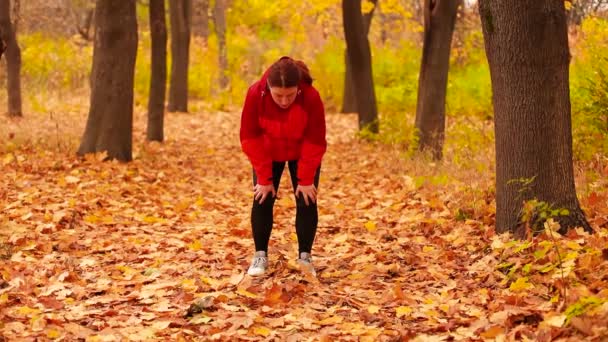 Väsynyt nainen juoksija pyyhkimällä hiki harjoittelun jälkeen puistossa - Materiaali, video