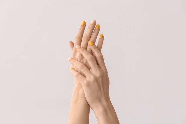 Female hands with beautiful manicure on light background - 写真・画像