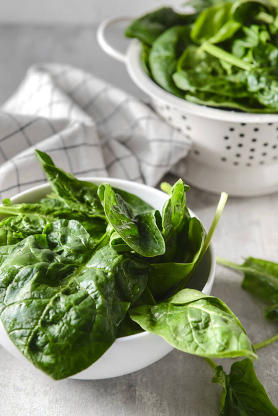 Bowl with fresh spinach leaves on light background, closeup - Photo, Image