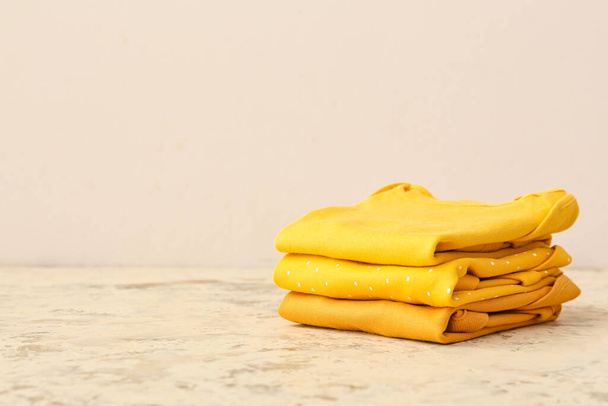 Empilement de vêtements de bébé sur fond de couleur - Photo, image