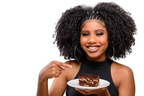 Улыбающаяся девушка указывает на итальянский соломенный пирог на тарелке в руке - Фото, изображение