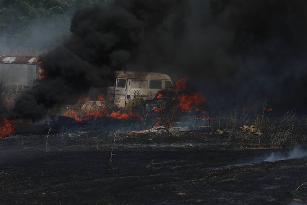Burning car in a field covered by fire - Photo, Image