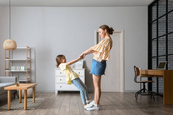 Молодая женщина и ее маленькая дочь танцуют дома - Фото, изображение