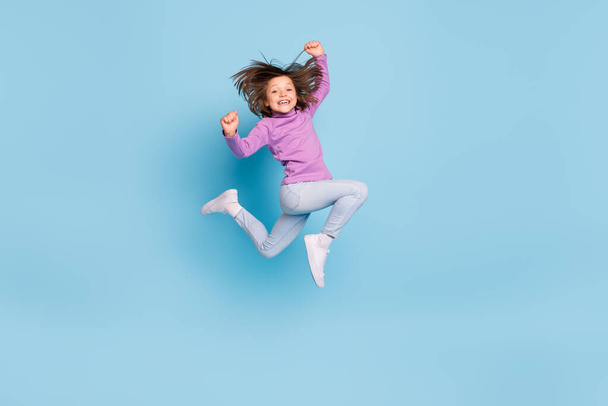 Full length body size photo small girl jumping up gesturing like winner isolated pastel blue color background - Valokuva, kuva