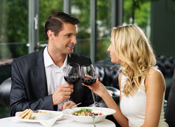 Couple gai dans un restaurant avec des verres de vin rouge
 - Photo, image