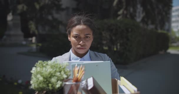失業問題。個人的な持ち物の箱と一人で立って落ち込んでアフリカ系アメリカ人女性マネージャーを動揺 - 映像、動画